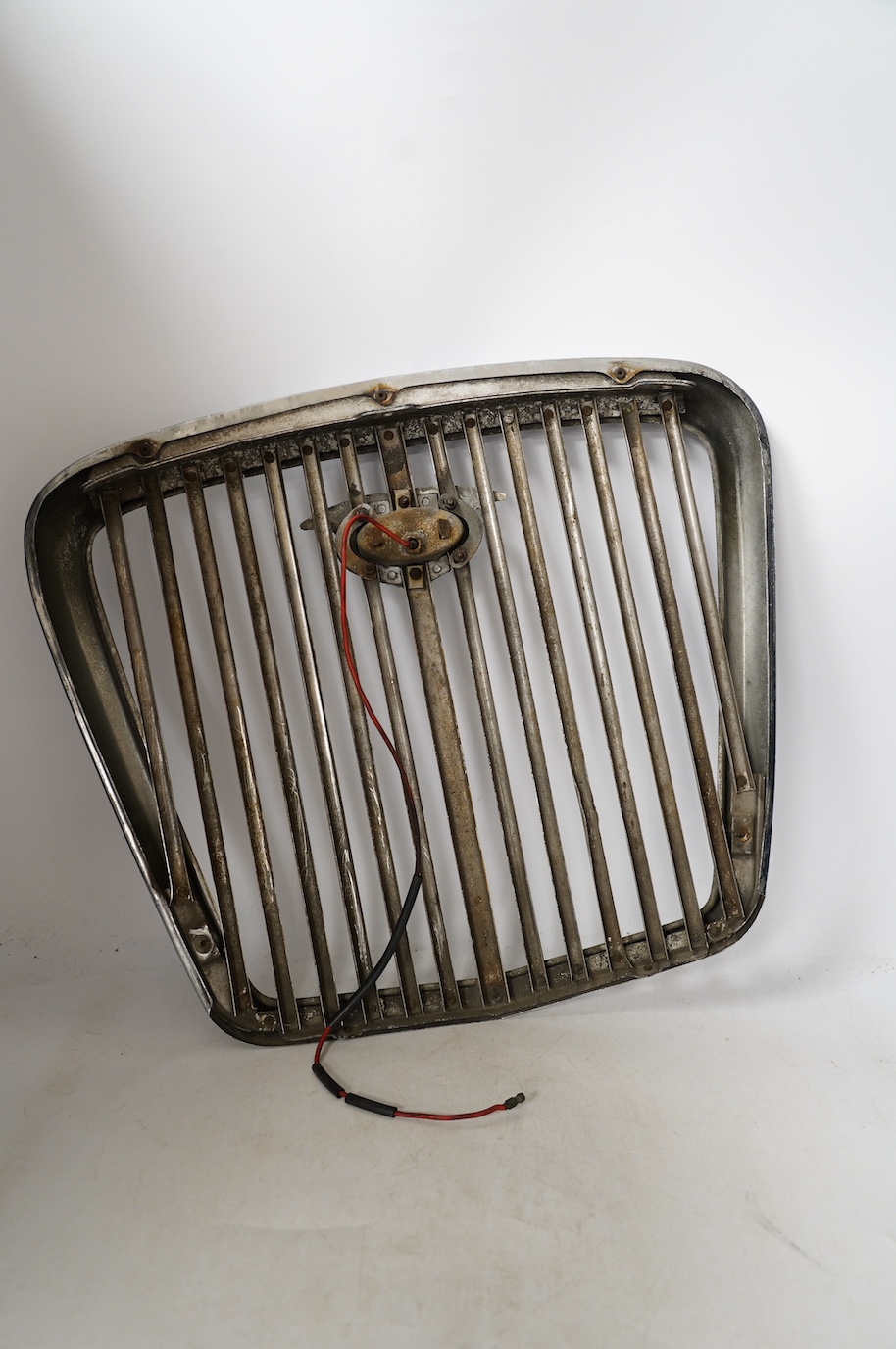 A 1950s Wolseley automobile radiator grill, with a lit logo to the centre of the grill, 40cm x 43cm. Condition - fair to good